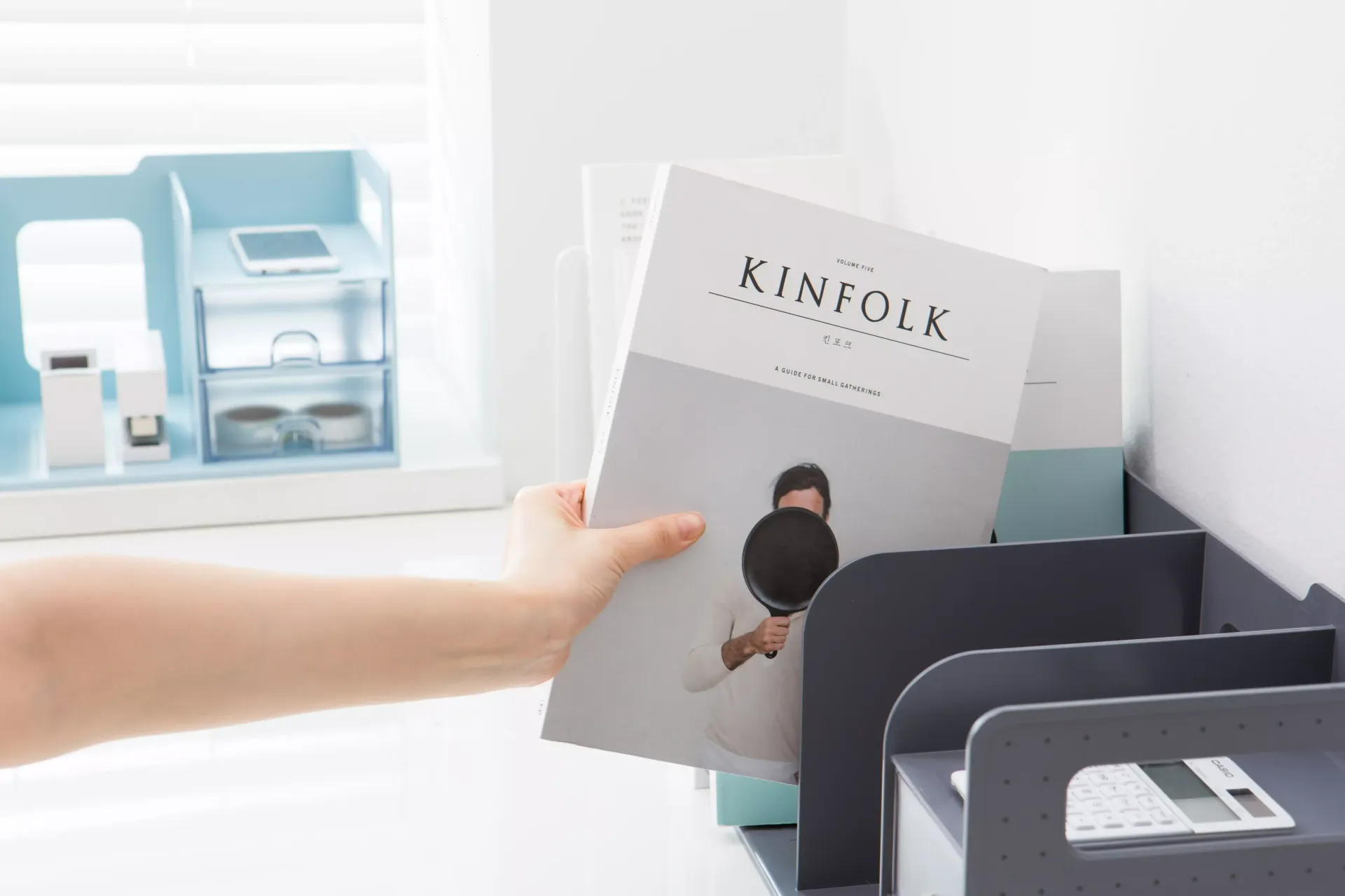 Una persona sostiene una revista en la mano.