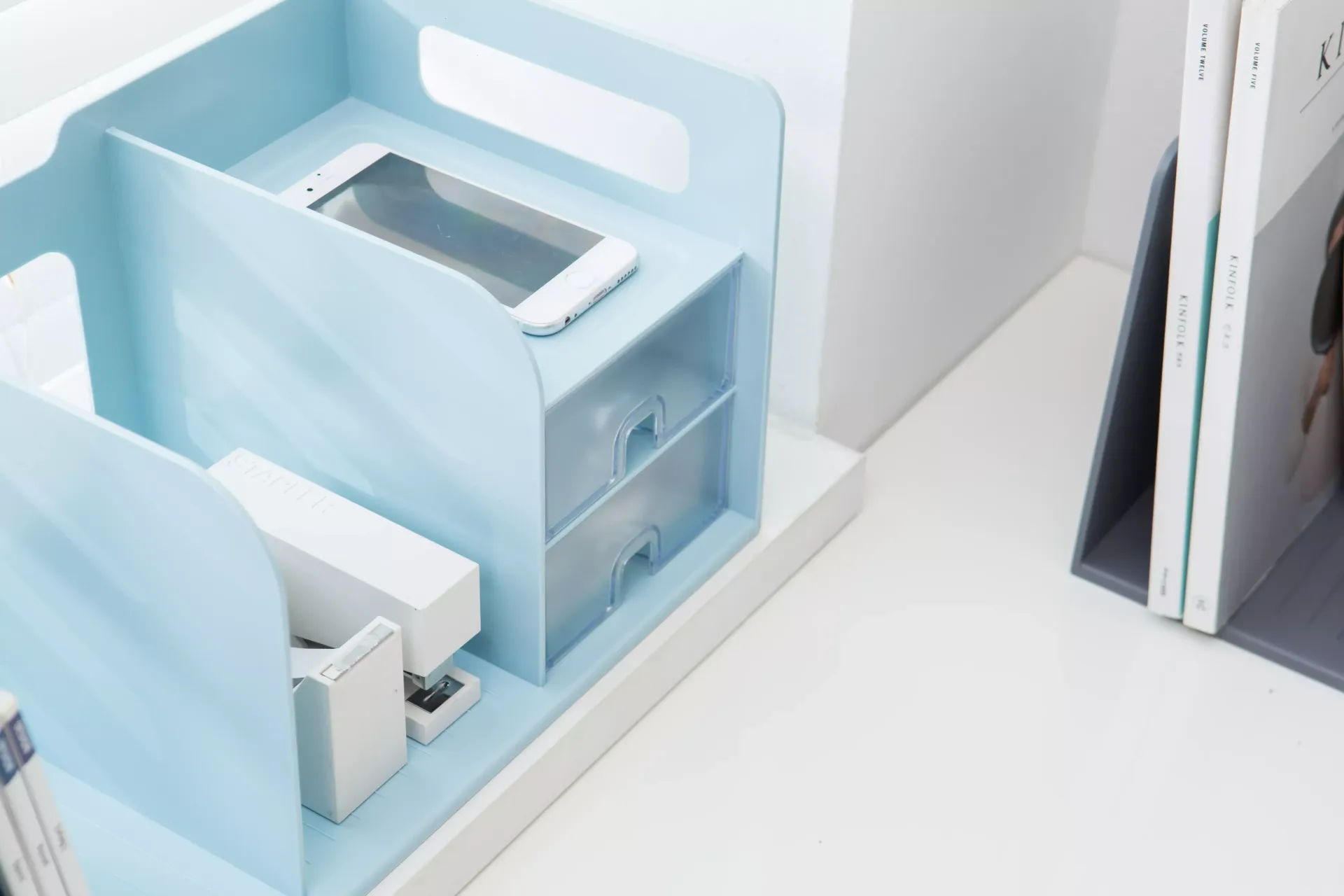 Un organizador azul con un móvil encima.