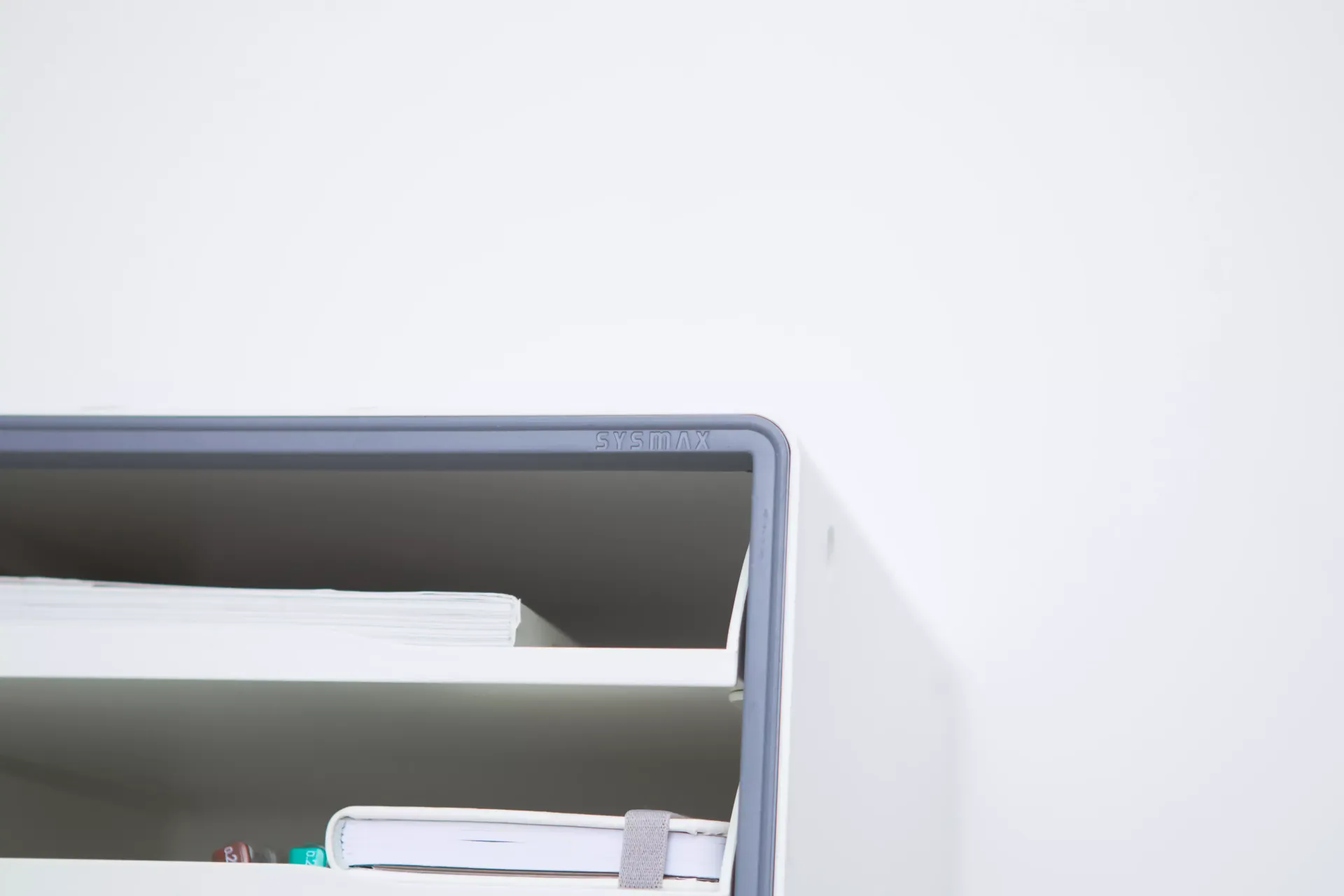 Um close de uma prateleira de gavetas com livros e papéis.