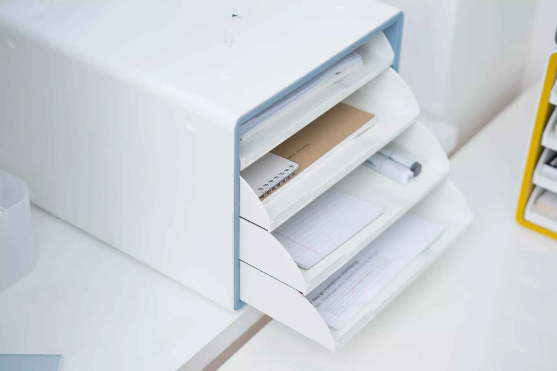 Una bandeja blanca y azul llena de papeles y sobres en los cajones.