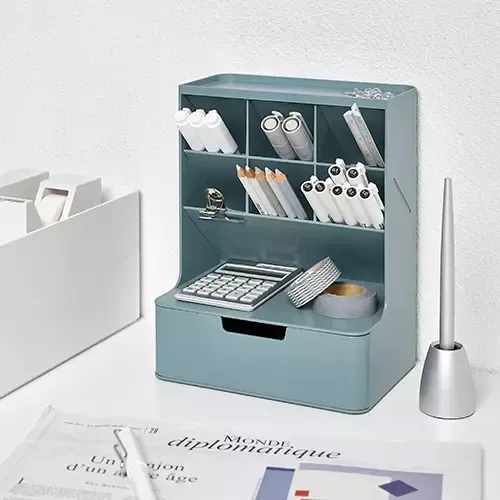 Un organizador de escritorio con un cajón y una calculadora.