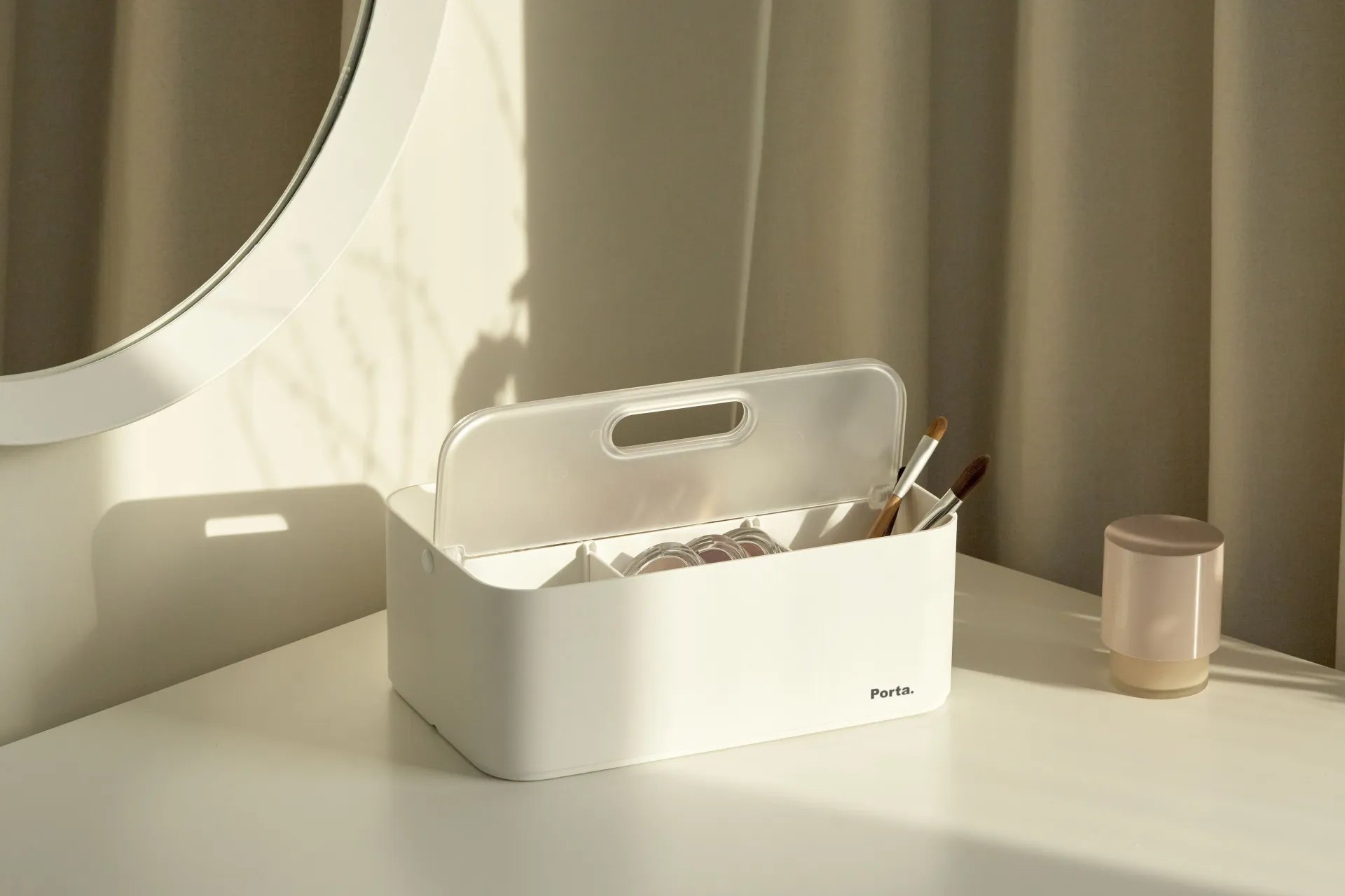 Una caja blanca está sobre una mesa blanca al lado de un espejo.