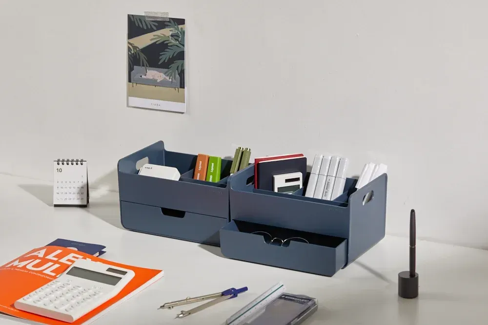 Una mesa con una calculadora, un cuaderno, un bolígrafo, un móvil y un calendario.