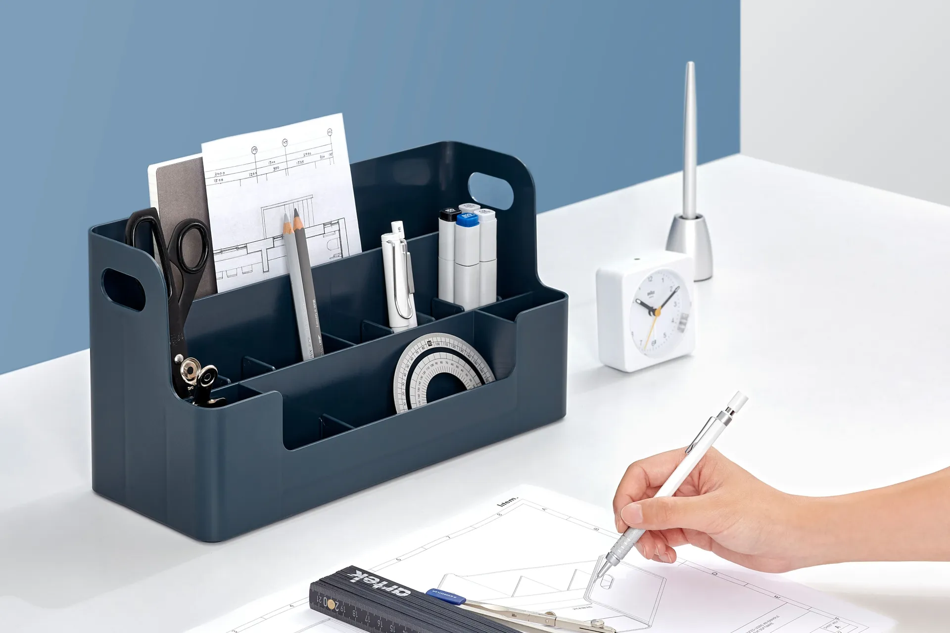 Una persona está escribiendo con un bolígrafo en un trozo de papel sobre una mesa.