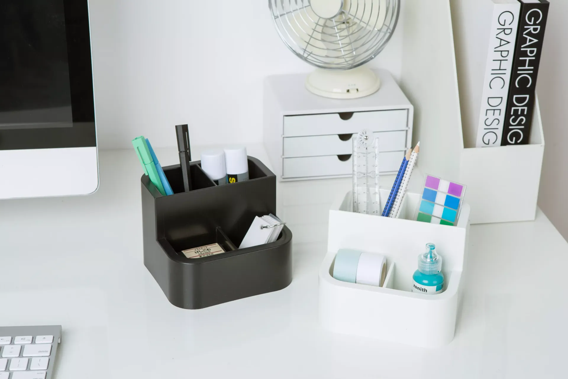 Una mesa con un ordenador, un teclado y un portalápices.