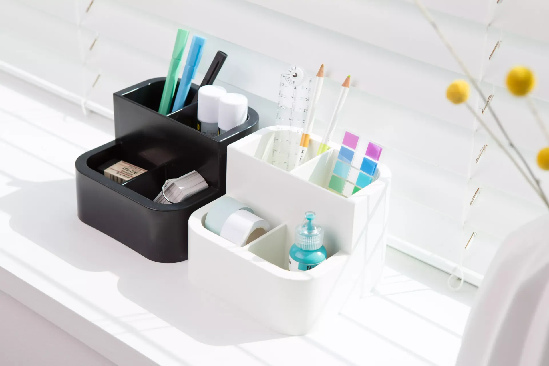 Hay tres recipientes llenos de varios objetos en el alféizar de una ventana.