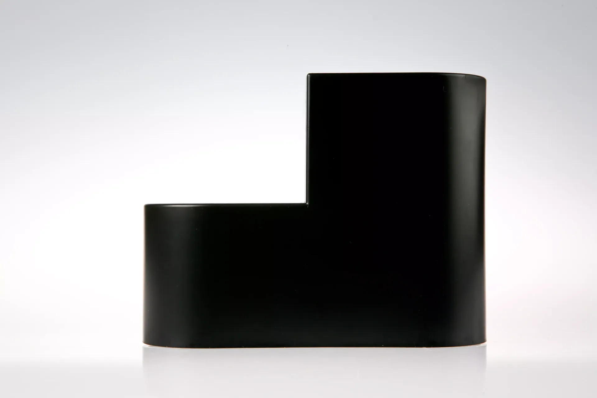 Un objeto negro está sobre una superficie blanca.