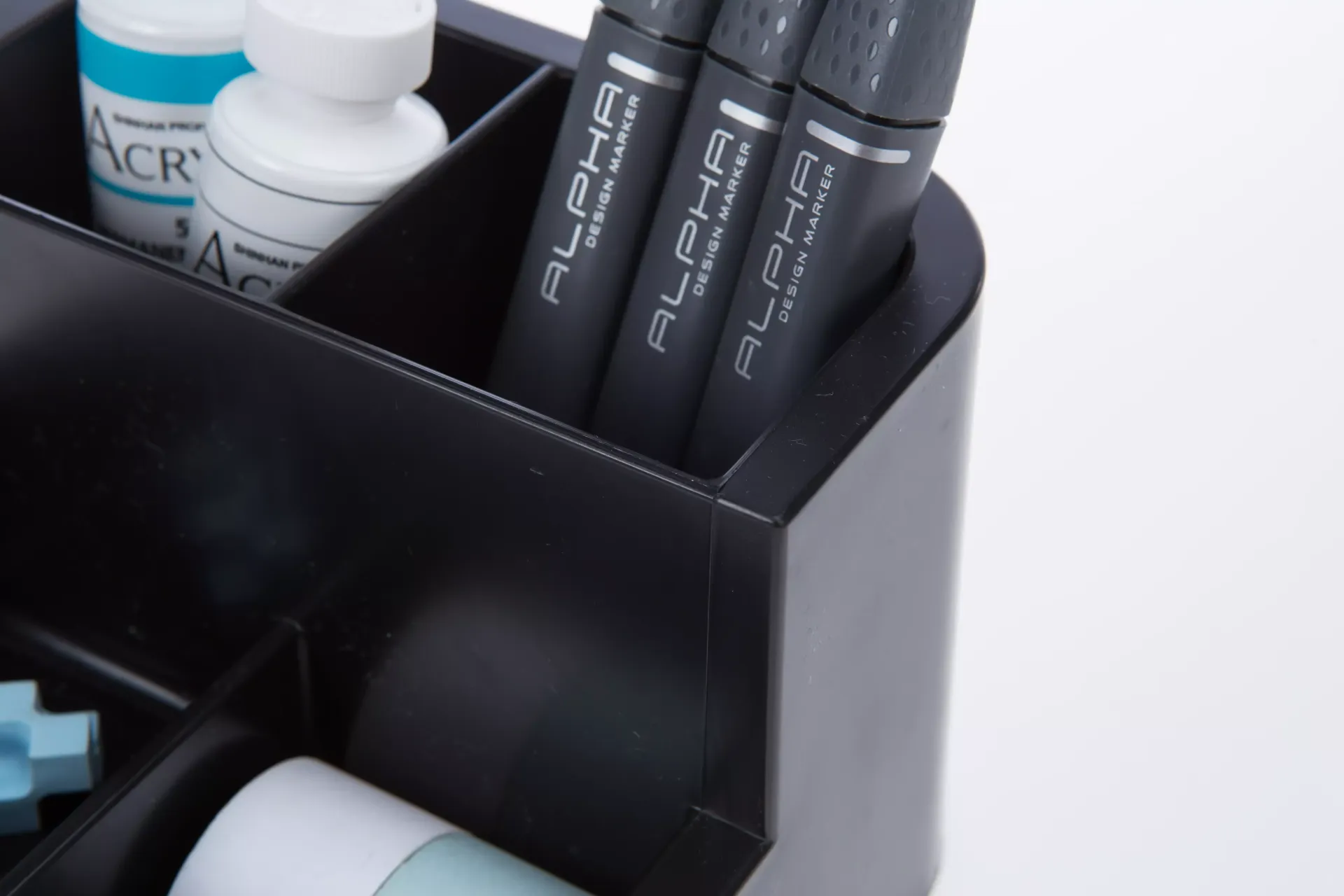 Tres bolígrafos alfa están en un recipiente negro.