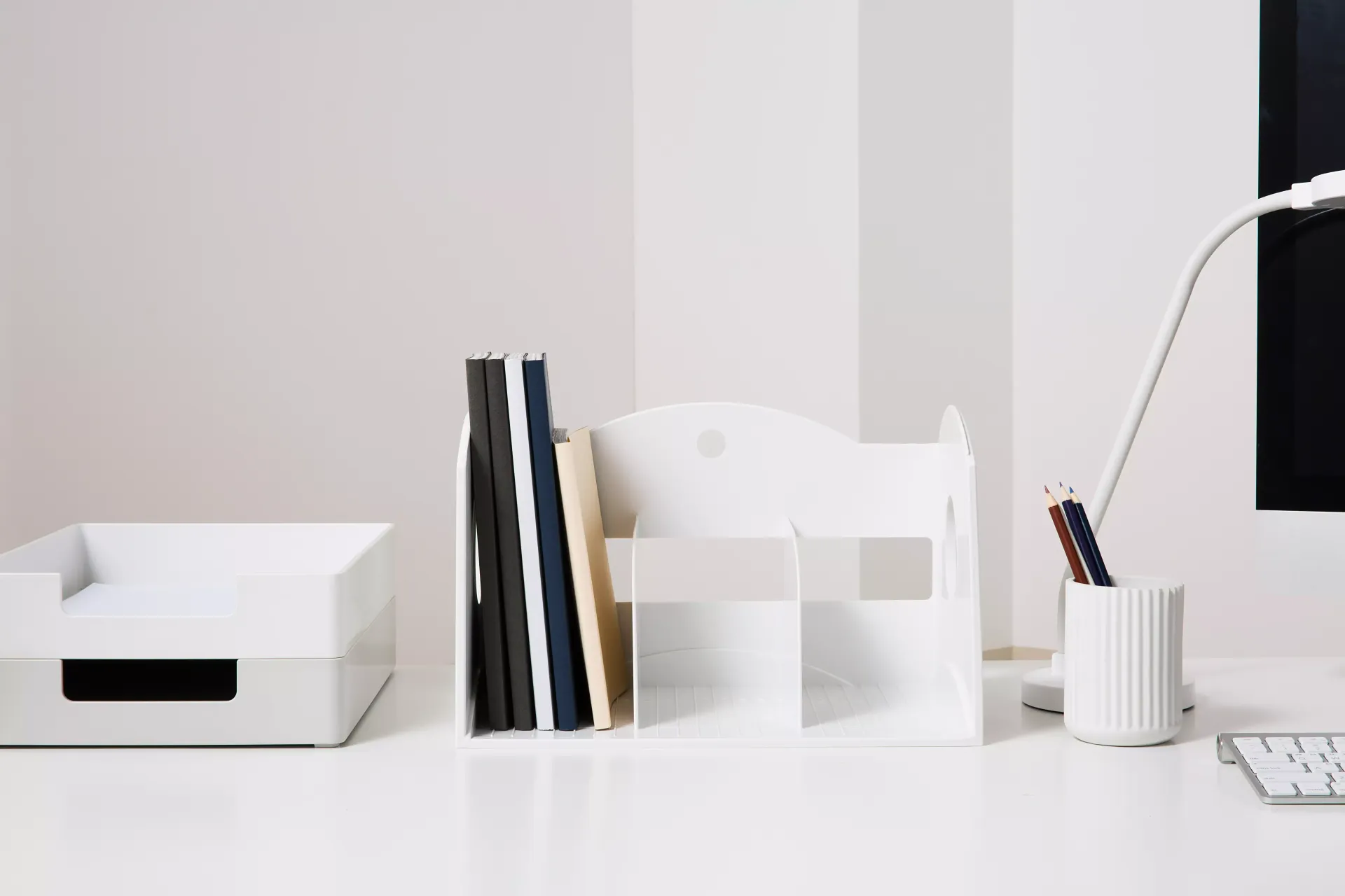 Una mesa blanca con un portilibros y un portalápices de Litem.