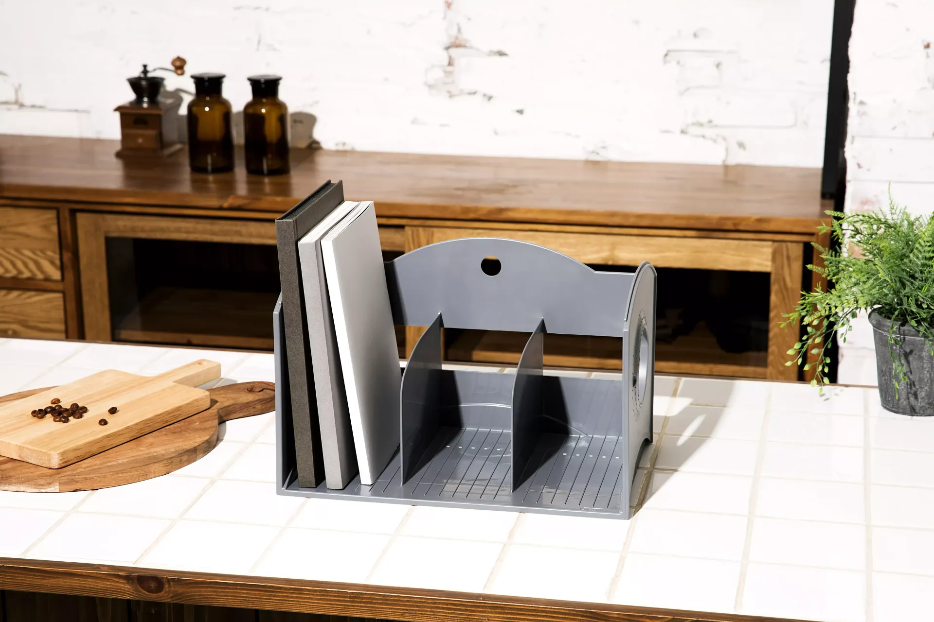 Hay un estante para libros encima de la encimera de la cocina.