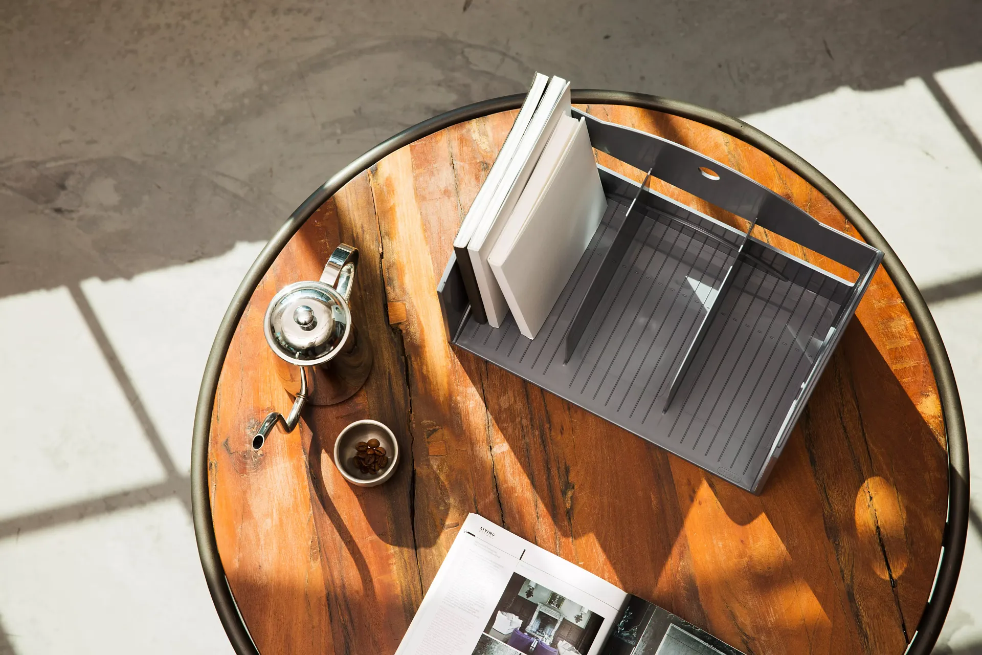 Una mesa de madera con un libro y una taza de café encima.