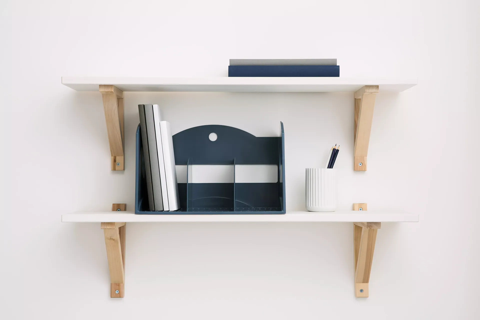 Dos estantes blancas con soportes de madera en una pared blanca.