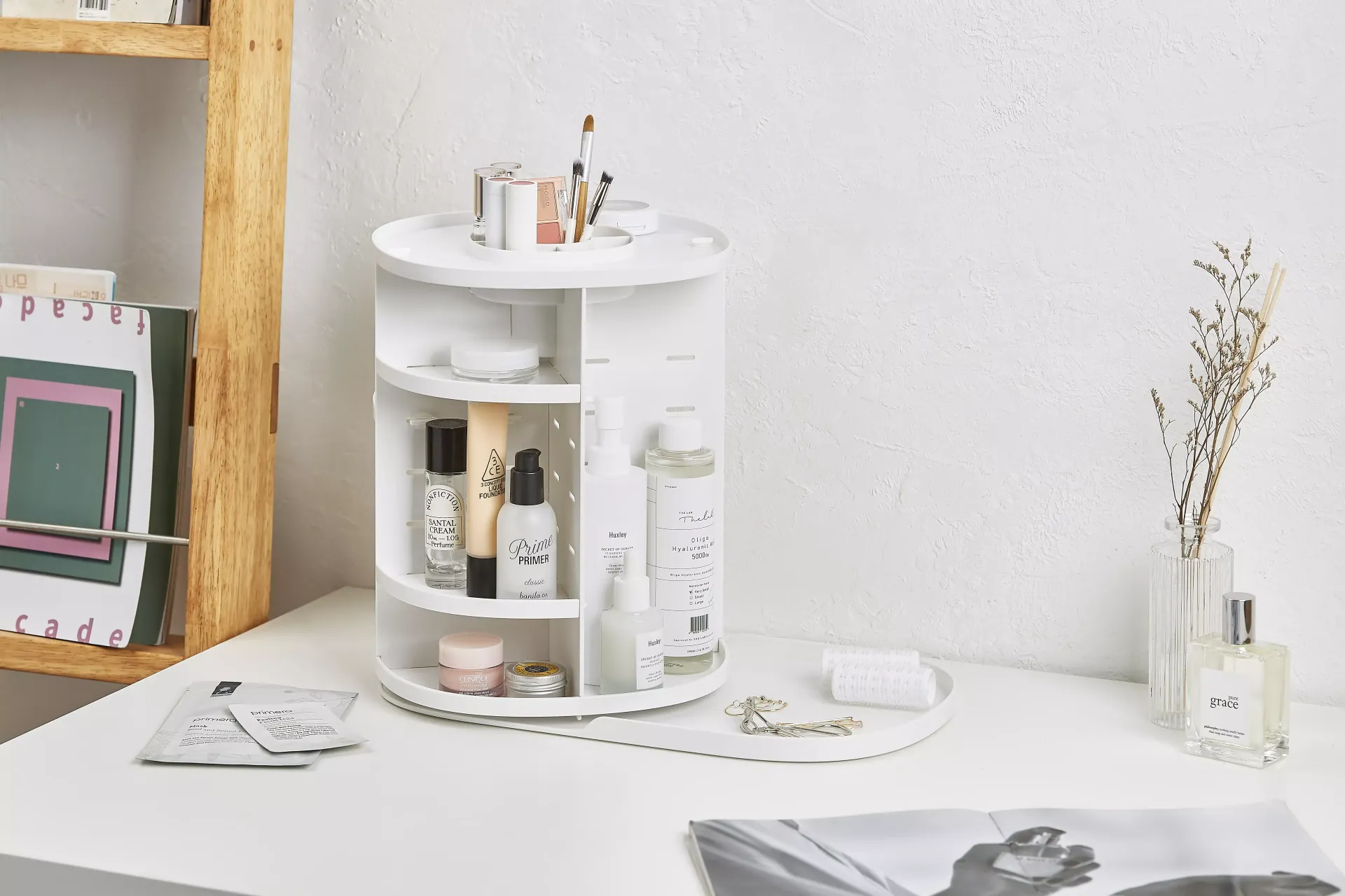 Un organizador de cosméticos blanco está sobre una mesa blanca.