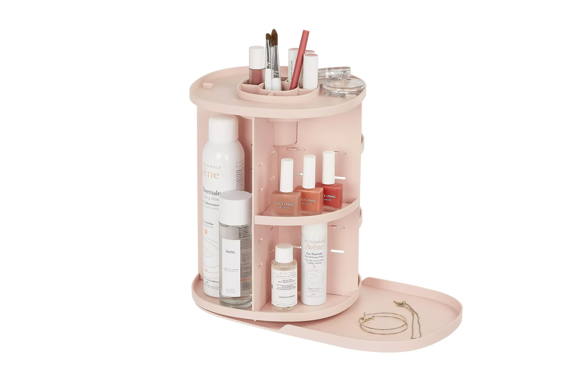 Un organizador de cosméticos rosa lleno de frascos y pinceles sobre un fondo blanco.