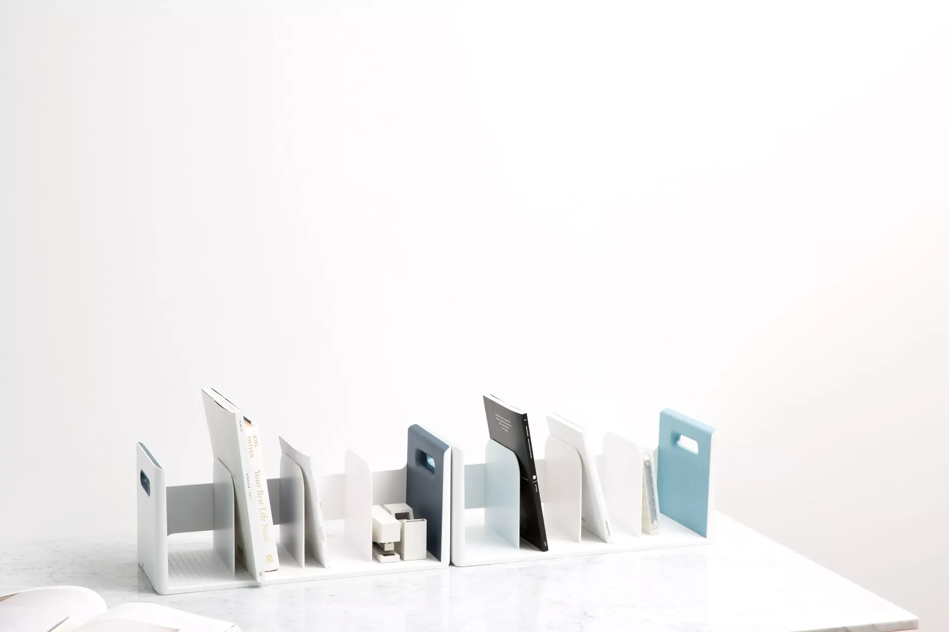 Una fila de libros sobre una mesa blanca.