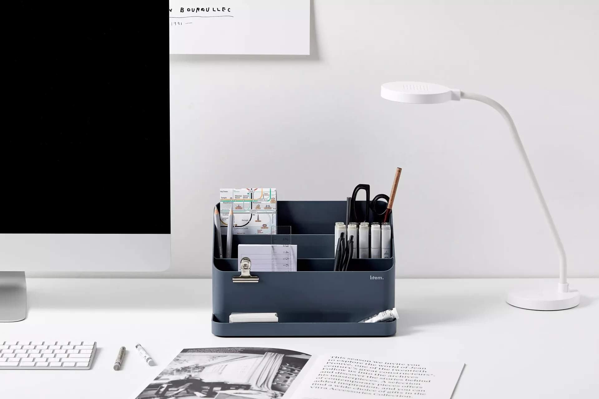 Una mesa con un ordenador y un organizador de escritorio.