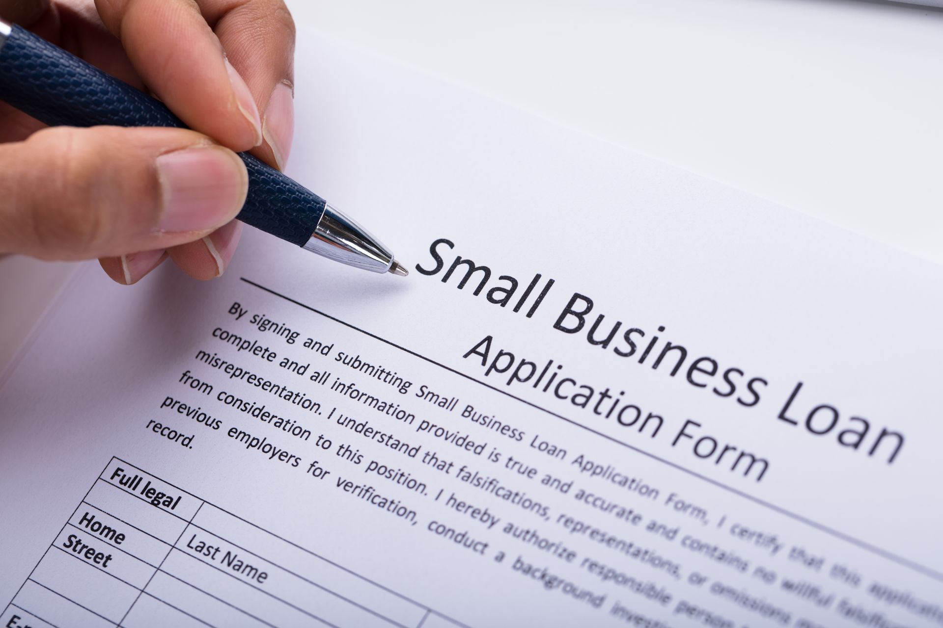 Business owner reviewing and completing a loan application form.
