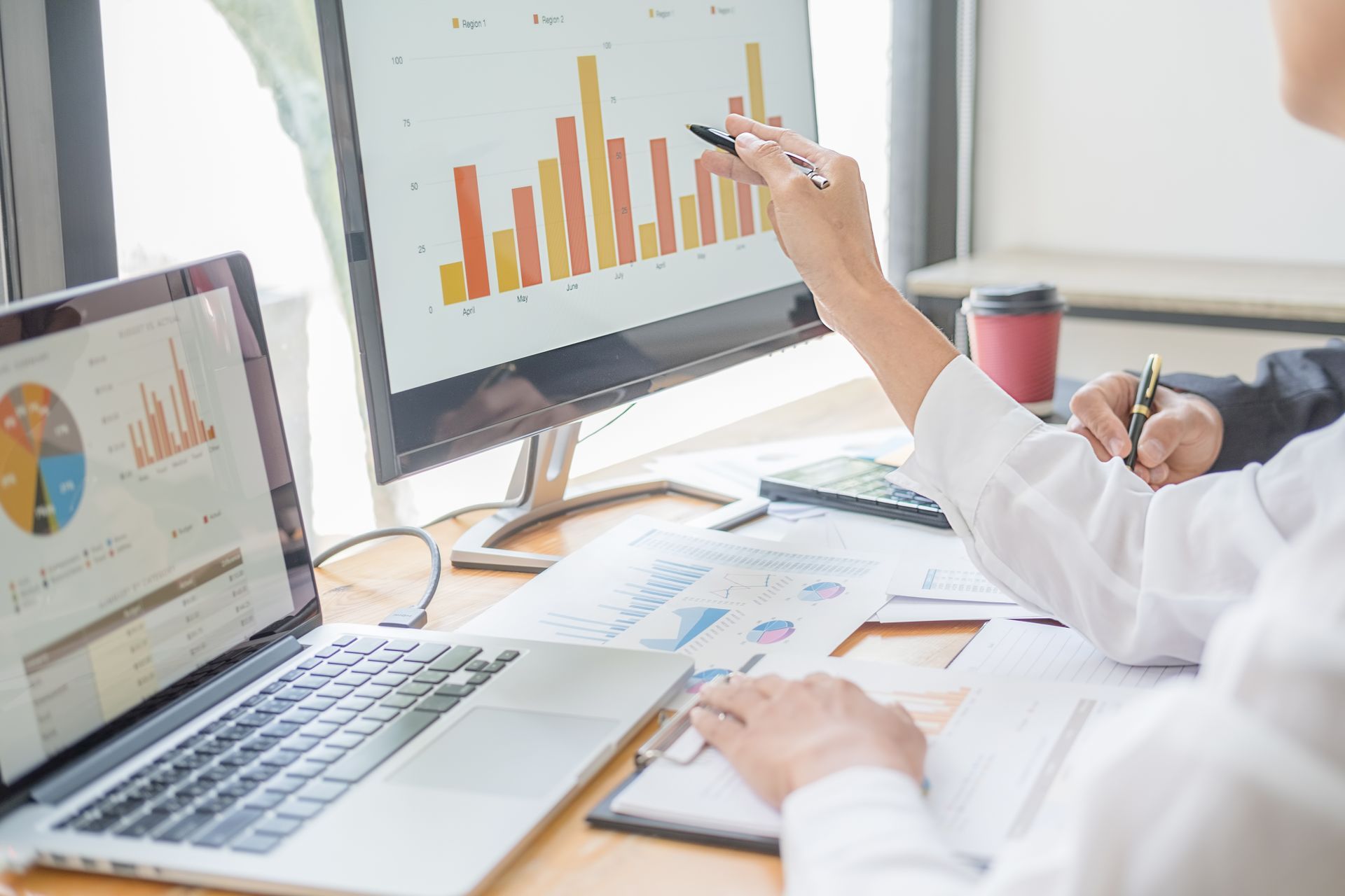 Accountant analysing spreadsheets and financial data on a computer.