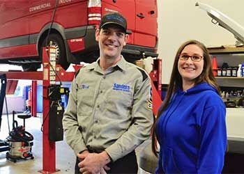 A man and a woman are standing next to each other in a garage.