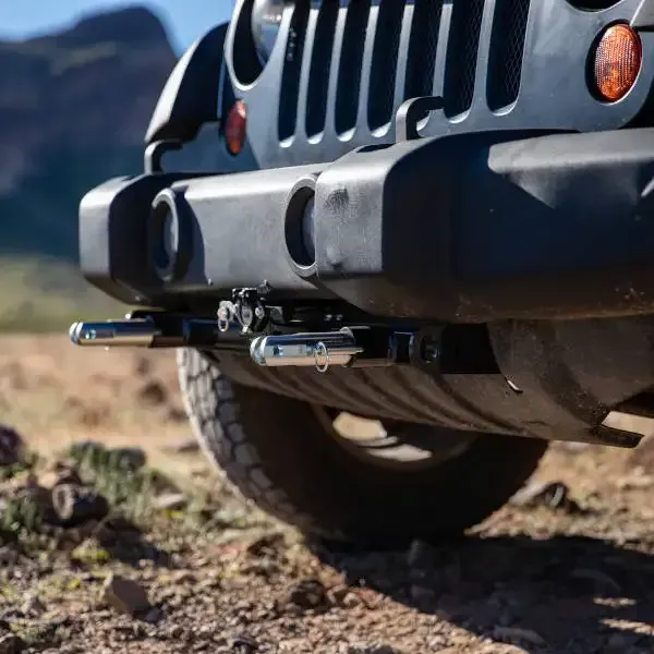 A black jeep is parked on a dirt road
