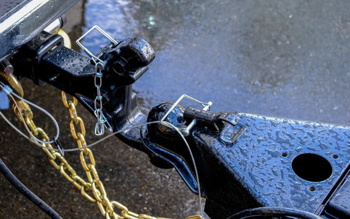 A close up of a trailer hitch with a chain attached to it Littleton Colorado Trailer Hitch Safety Guidelines