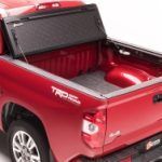 The back of a red truck with the bed open.