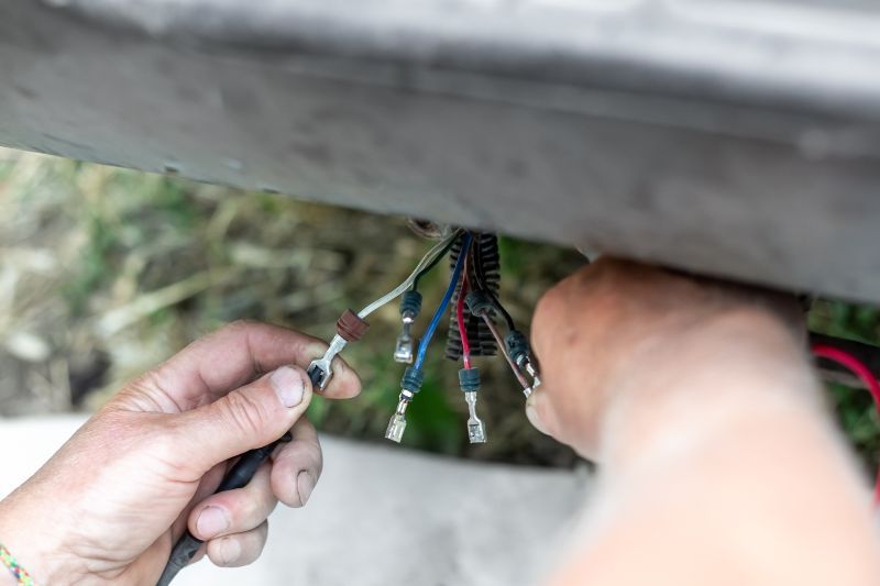 A person is working on a wire with a pair of pliers.