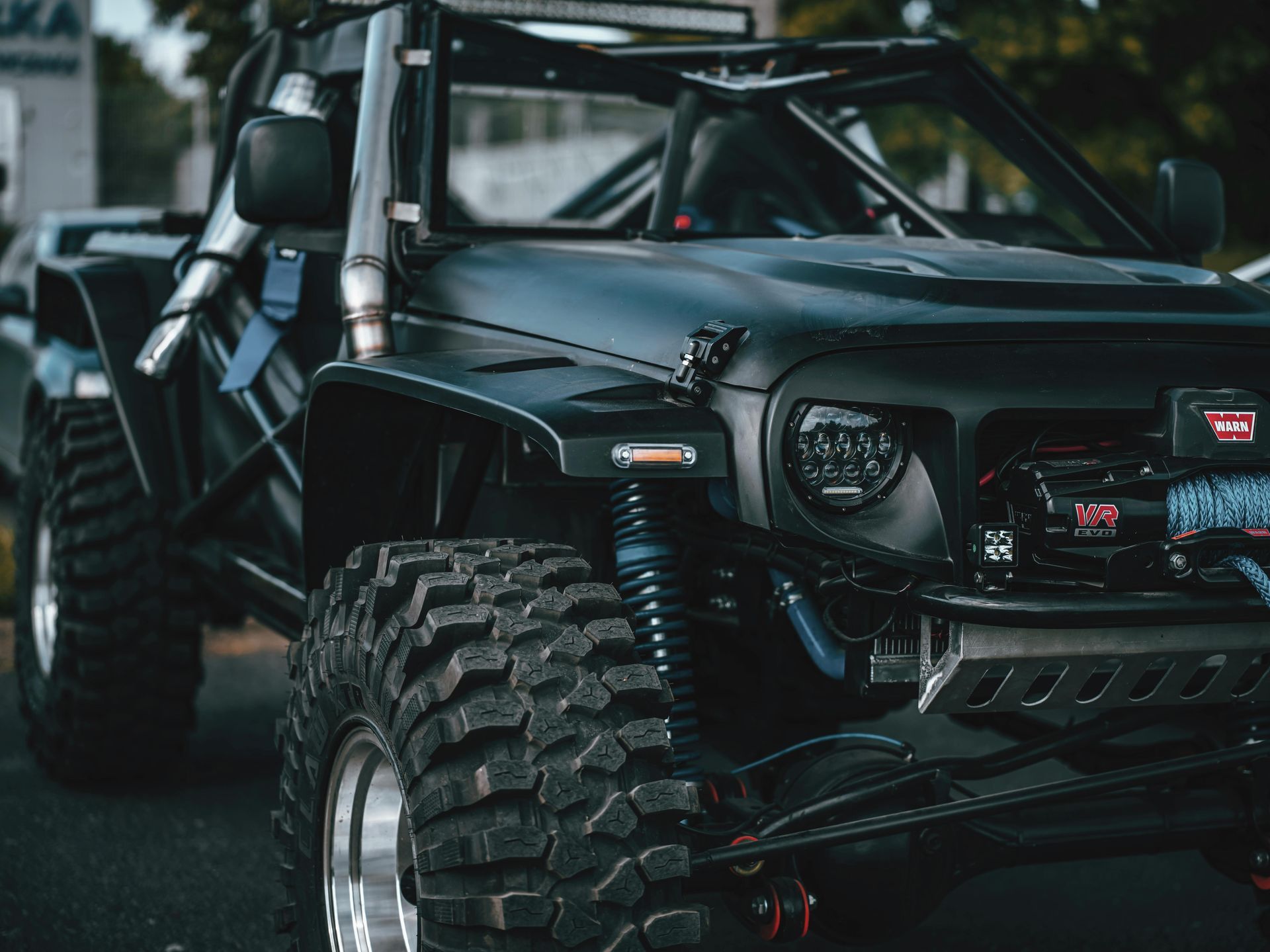 A black jeep is parked on the side of the road.