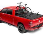 A red truck with two bikes in the bed.