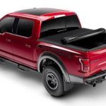A red pickup truck with a black roof on a white background.