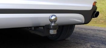 A white car with a tow ball attached to the back of it.