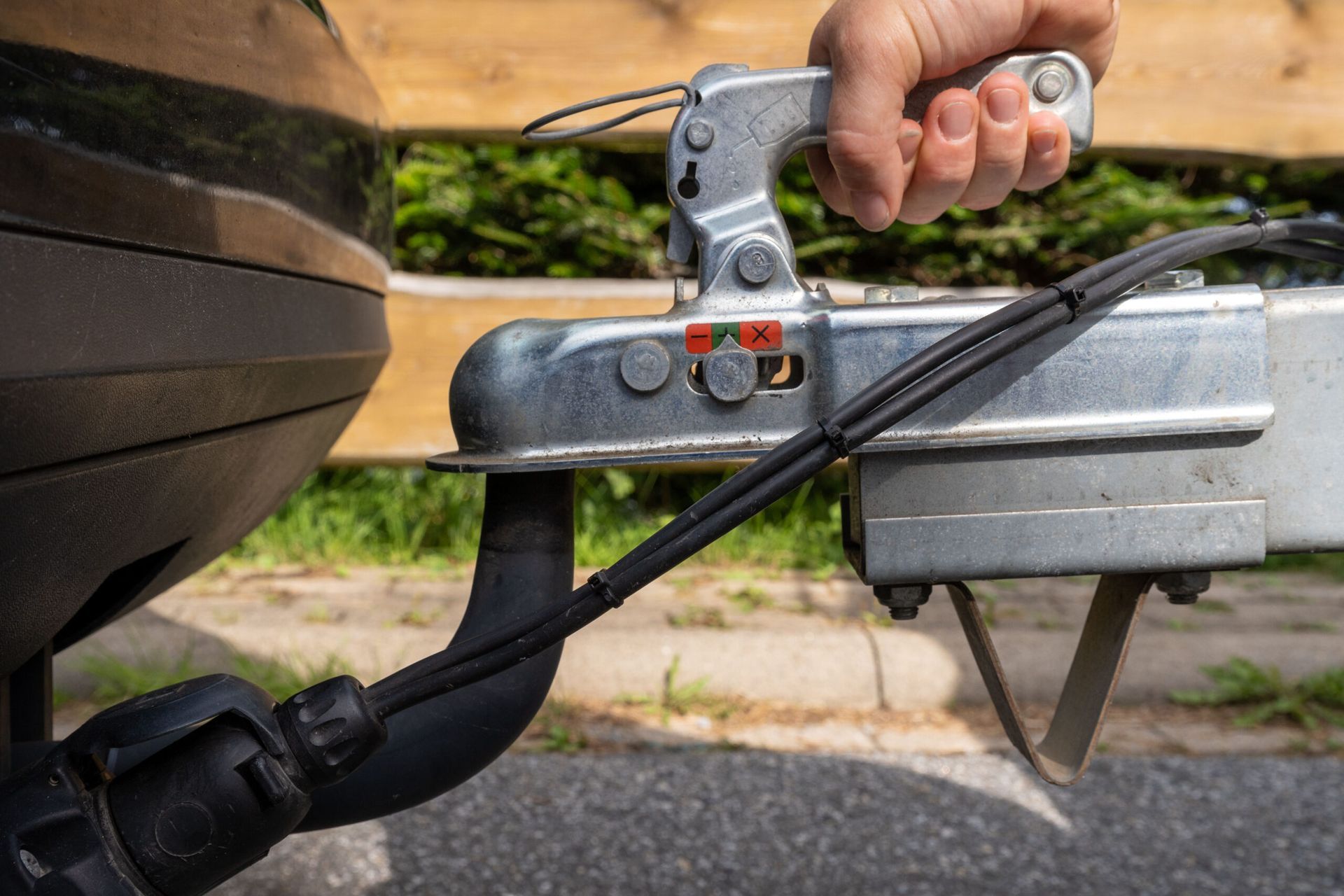 A person is attaching a trailer to a car Littleton Colorado Common Trailer Hitch Safety Issues