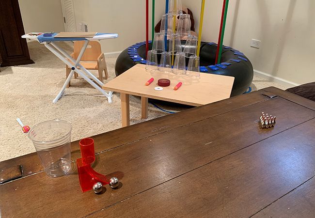 A wooden table with a bunch of Montessori materias on it in a room.