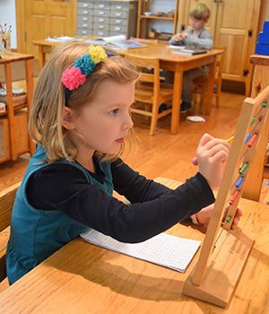 A girl working with Montessori math materials