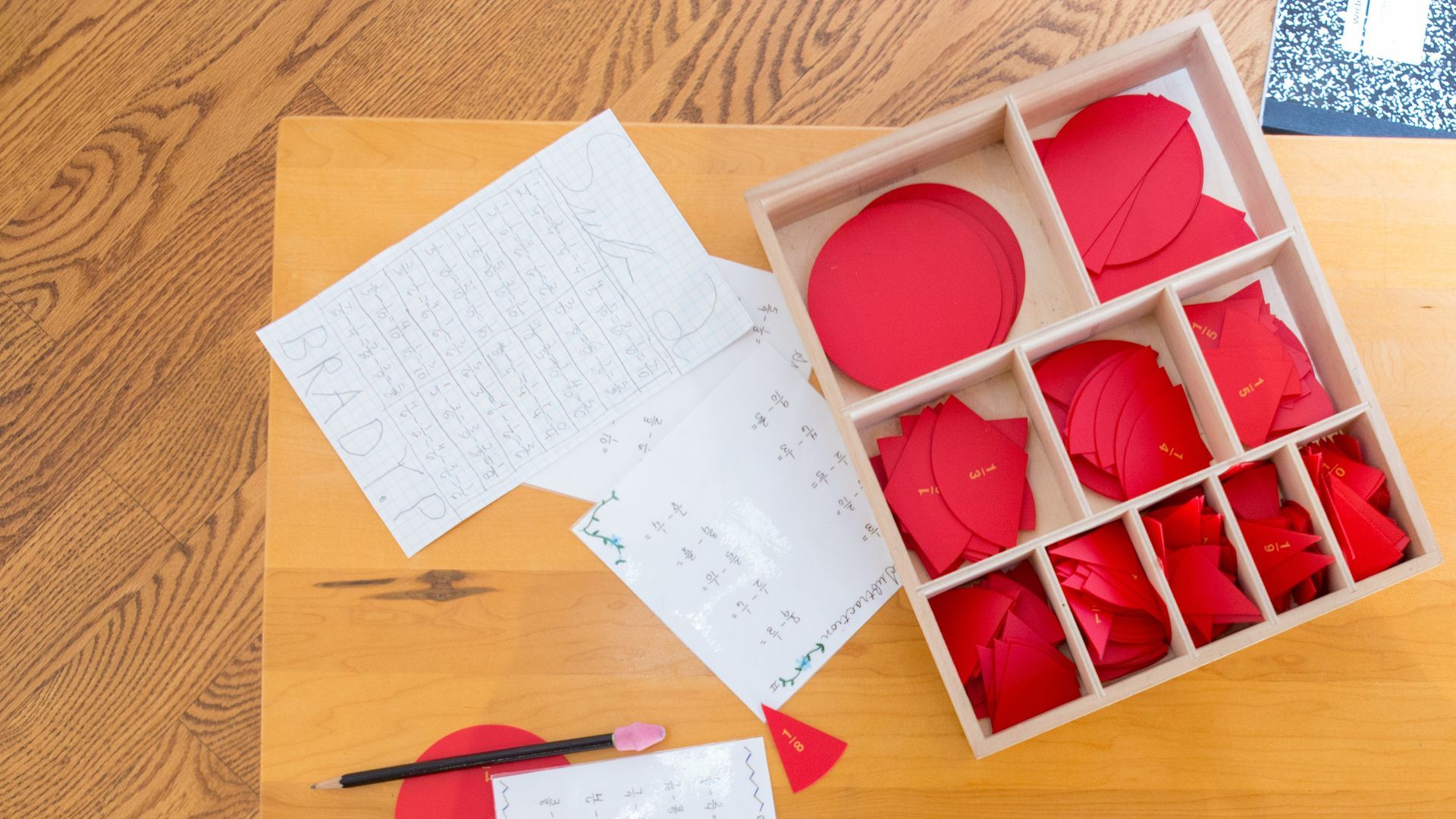 A wooden table with a box of red circles on it.