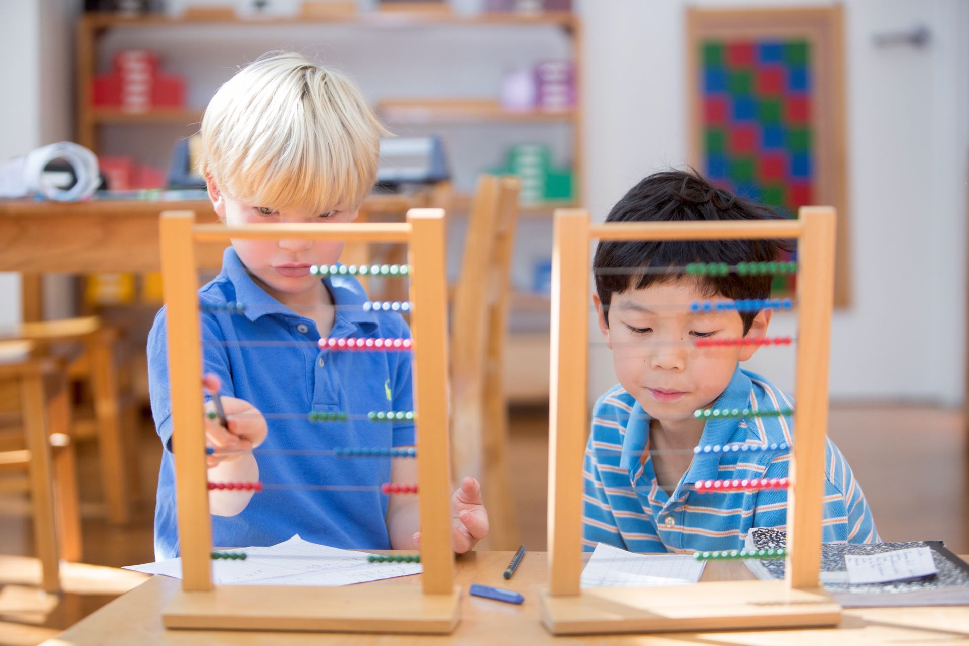 Montessori children are working with abacus in a classroom.