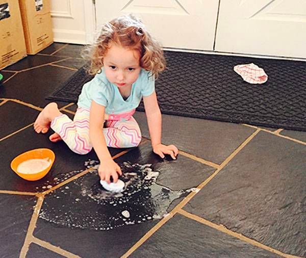 A little girl is playing with soap on the floor