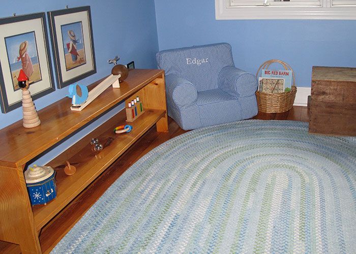 A Montessori class room with a blue chair and a rug