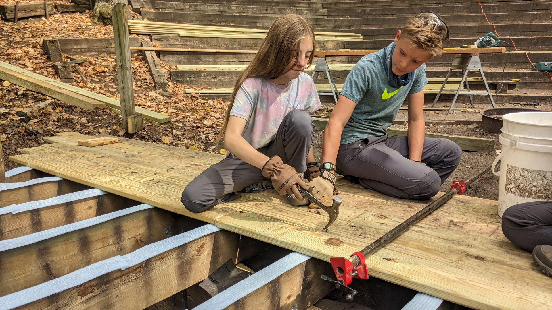 Montessori children are working on a wooden deck.