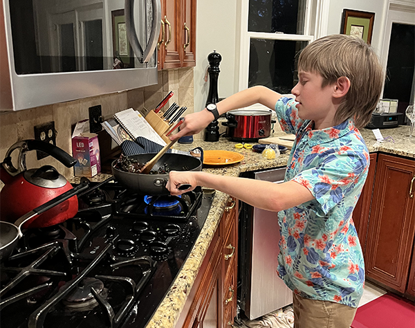 A child in the second plane of development uses the stove independently to cook dinner