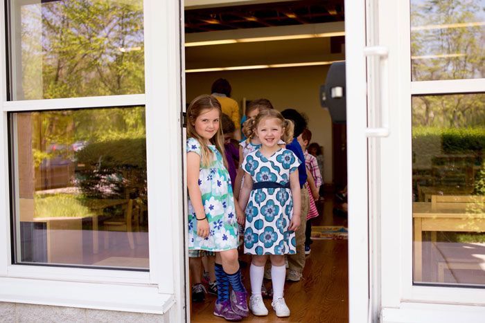 A group of young girls are standing in a doorway.