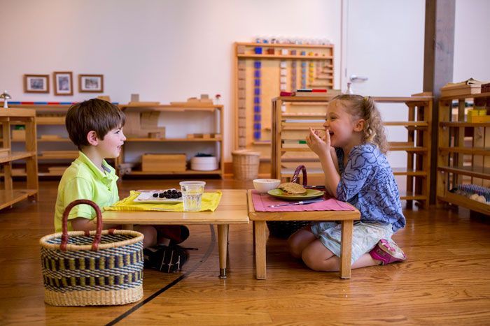 A boy and a girl are sitting at a table in a classroom.