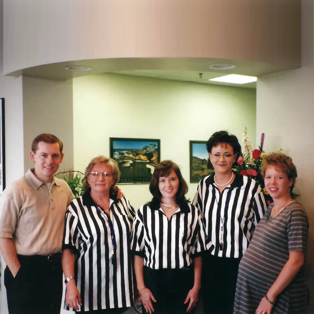 A group of people wearing striped shirts pose for a picture