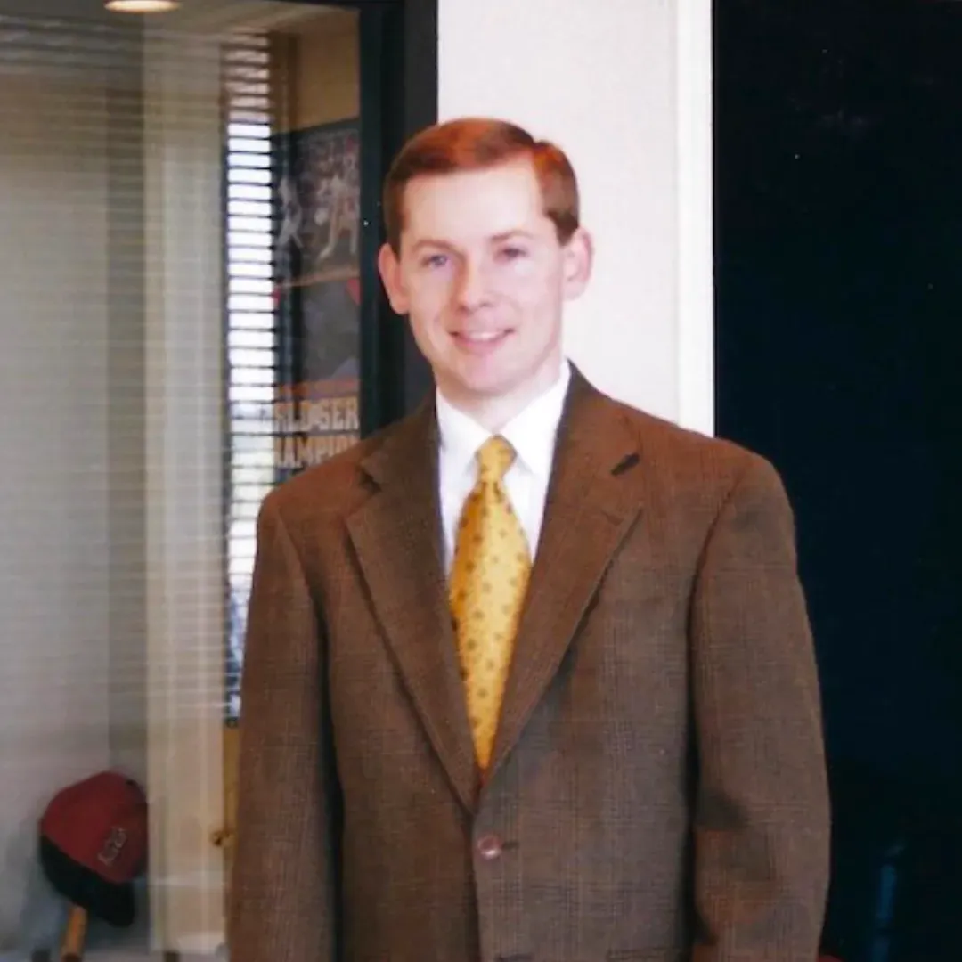 A man in a suit and tie is smiling for the camera