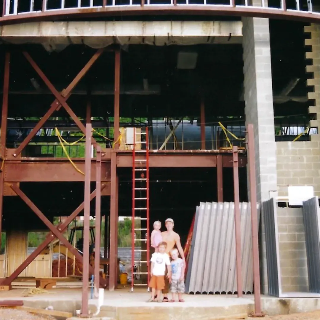 A group of people standing in front of a building under construction