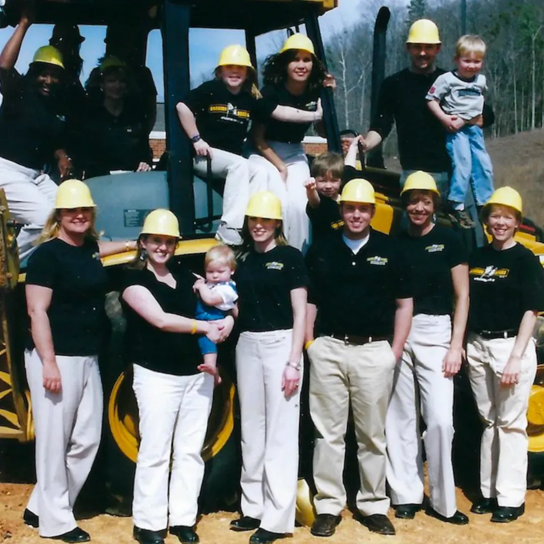 A group of people wearing hard hats are posing for a picture