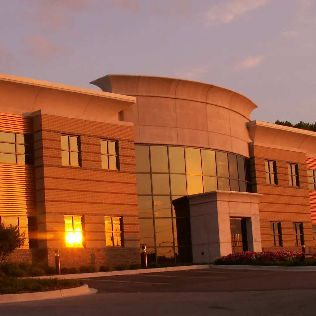 A large building with a lot of windows and a sunset in the background