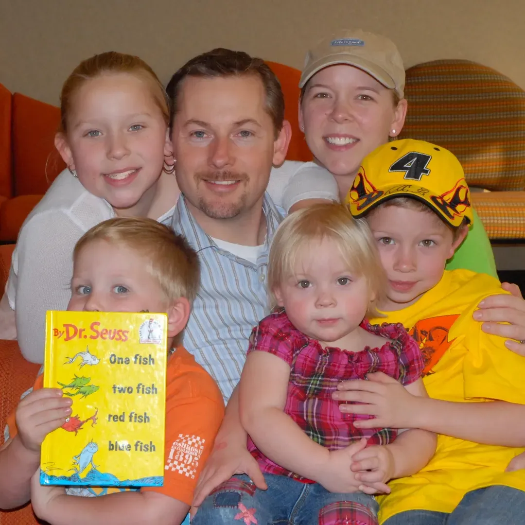A family posing for a picture with a book titled dr. seuss
