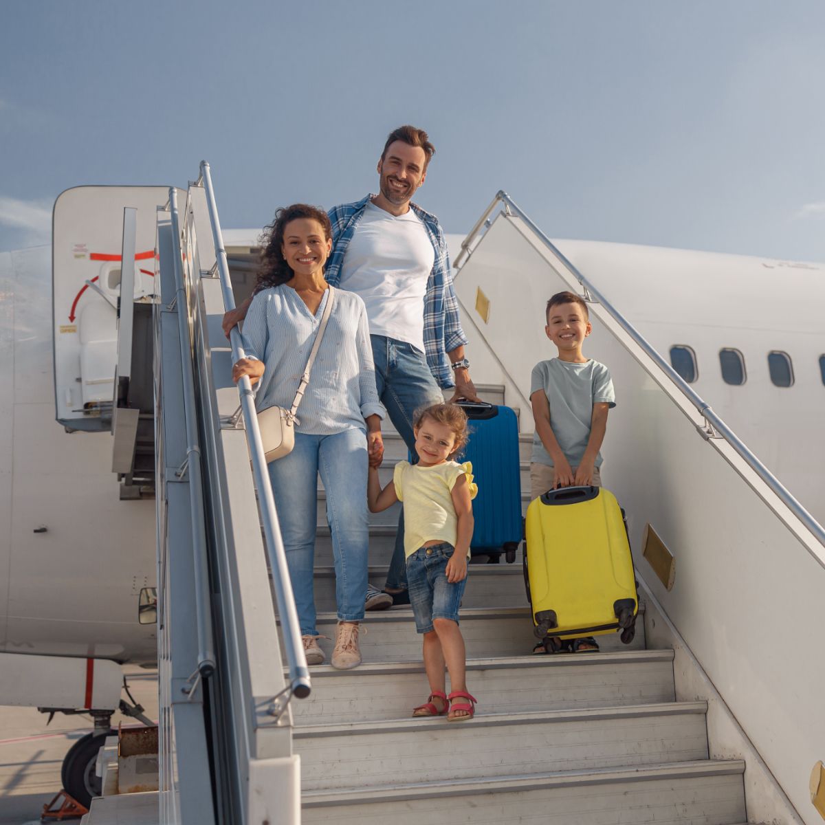 A family is boarding an airplane with their luggage