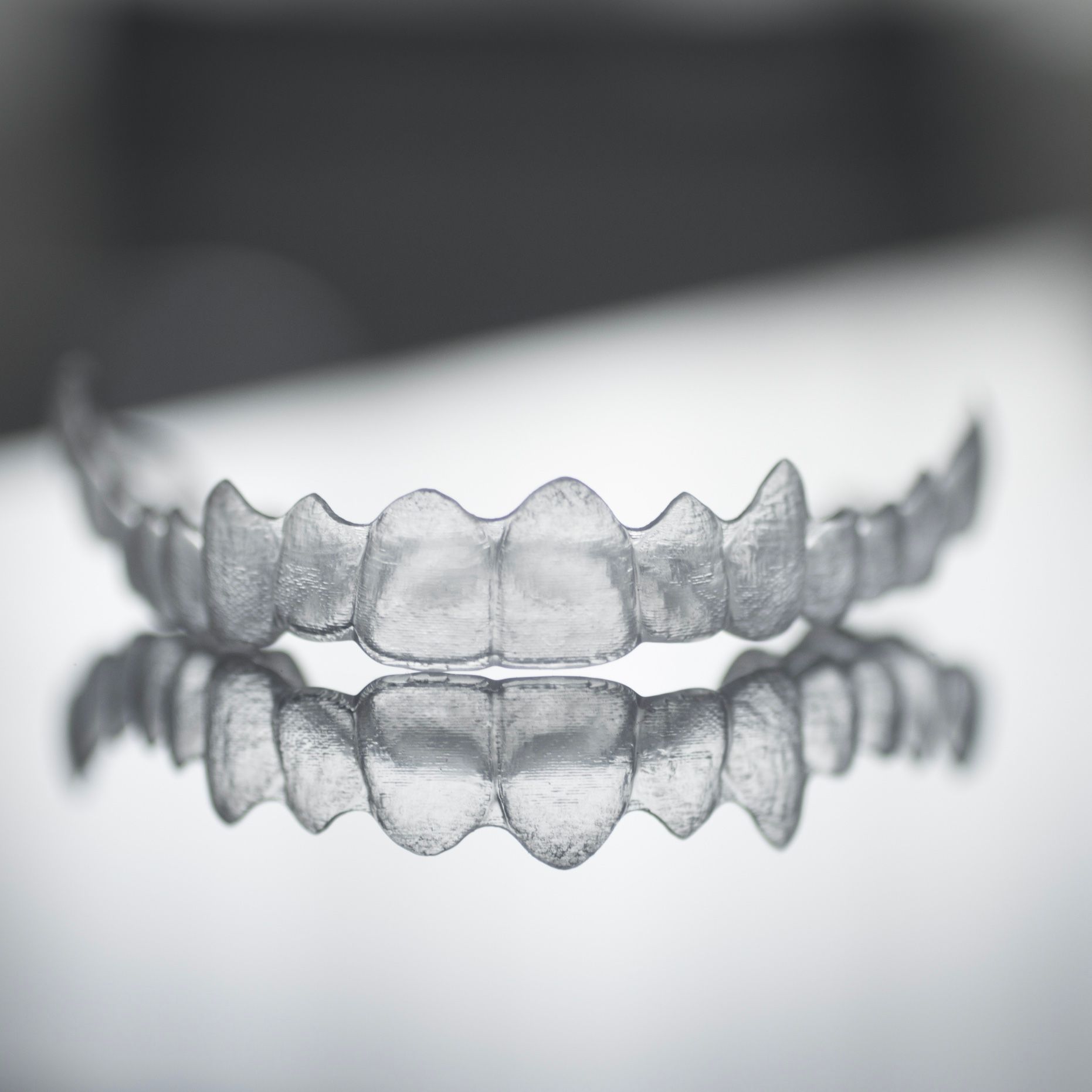clear aligners sitting on a reflective surface